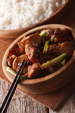 Kung pao chicken in a bowl close up and rice. vertical