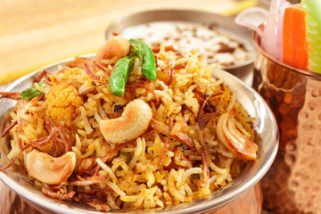 Vegetable Biryani, Indian cuisine accompanied with fresh slice of carrot, cucumber, onion and Raita garnished with fried beans,onion and cashew nuts