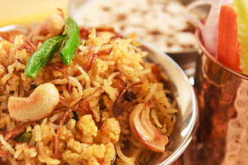 Vegetable Biryani, Indian cuisine accompanied with fresh slice of carrot, cucumber, onion and Raita garnished with fried beans,onion and cashew nuts