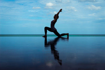 silhouette Reflextion of low lunge in Yoga pose with blue sky