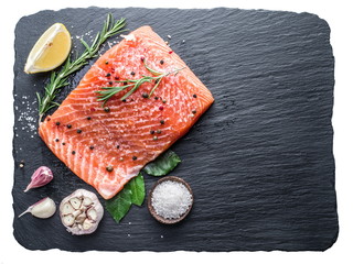 Fresh salmon on the black cutting board. File contains clipping