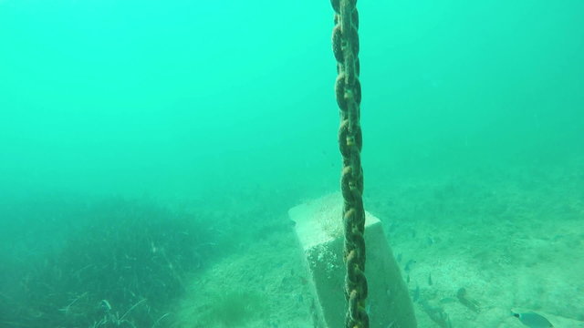 slow motion diving and raising along chain to surface over the rocky sea bottom of Adriatic sea