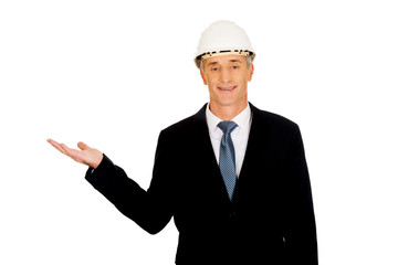 Businessman with hard hat holding copyspace