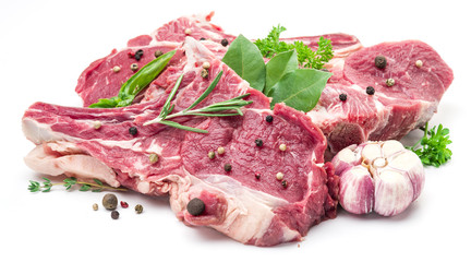 Raw pork meet steaks with spices on the white background.