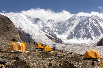 Base Camp of High Altitude Expedition Many Orange Tents Located on Side Rock Moraine of Glacier in Severe Snow and Ice Peaks Valley