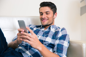 Man lying on the sofa with smartphon
