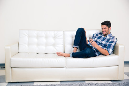 Man using smartphone on the sofa