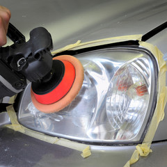 Car light repairing, hand with tool polish headlight 