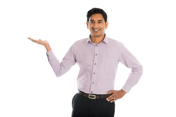 portrait of young businessman pointing at invisible product over