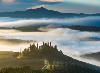 Fototapeta na wymiar Beautiful foggy landscape in the middle sunrise. Italy, Tuscany.