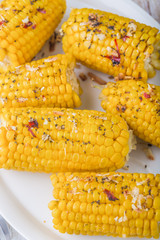 Roasted sweet corn on the cob on white plate