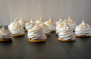 A selection of delicious mini meringues arranged on a wooden boa