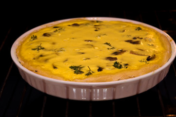 pie with cheese, mushrooms and spinach in a ceramic baking