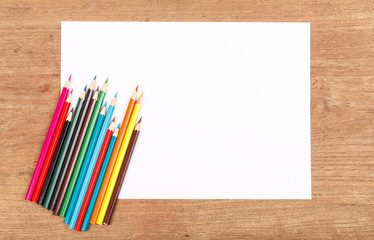 Obraz premium white paper with color pencil on wooden table