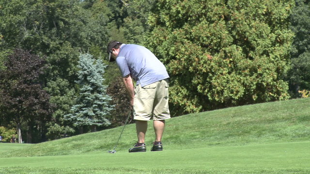 Lefty golfer putts ball