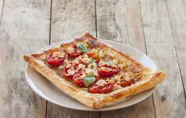 Tomato tart, puff pastry topped with mustard, cheese and cherry toamtoes.