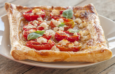 Tomato tart, puff pastry topped with mustard, cheese and cherry toamtoes.