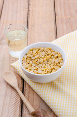 Healthy golden soil oil with a cup of raw soybean