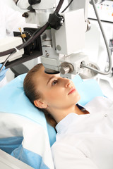 Laserowa korekcja wzroku.Pacjentka  na sali operacyjnej podczas zabiegu chirurgii okulistycznej - obrazy, fototapety, plakaty