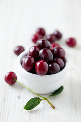 cherries in a bowl on wooden surface