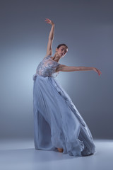 The beautiful ballerina dancing in blue long dress 