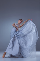 The beautiful ballerina dancing in blue long dress 