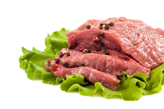 Raw meat and fresh green salad on white background.