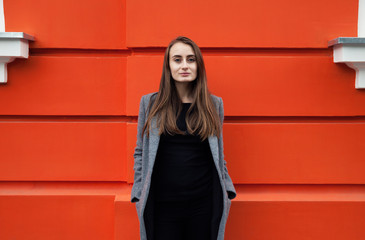 Yound woman on the orange wall