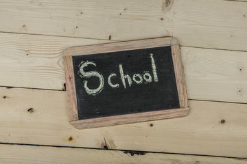 Lavagna con scritta school su sfondo di legno