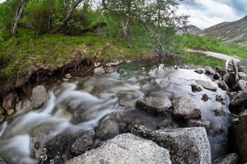 Mountain stream coming down from the tops of the mountains in Khibins, long exposure, wide angle