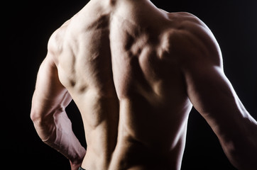 Fototapeta premium Muscular man posing in dark studio