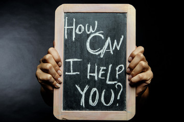 mani mostrano lavagna con scritta " come posso aiutarti?"