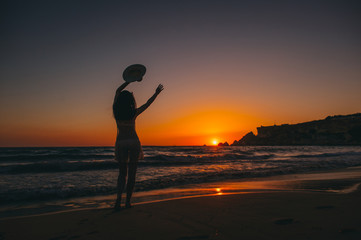 Fototapeta na wymiar Sea beach girl silhouette, sunset
