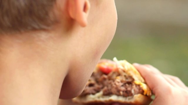 Close up of huge hamburger in hands of child