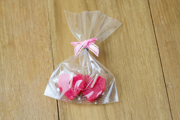candle heart shape in plastic bag on wooden board