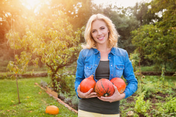 Beautiful woman harvesting pumpkins