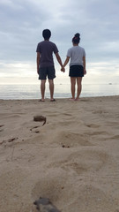 back of men and women couple hand on beach