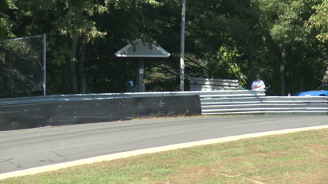 Flagman signals race car drivers