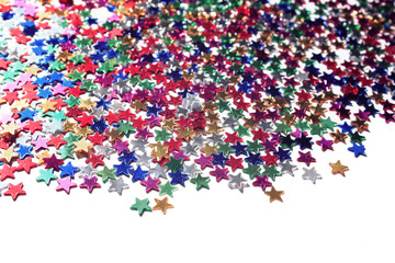 Scattered glittering stars confetti. Close up. Star background with copy space. Toned  photo. Text frame with plenty of colorful stars.