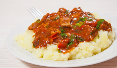 meat in sauce with mashed potatoes