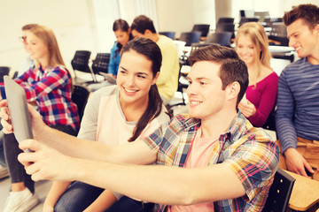 group of smiling students with tablet pc