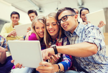 group of smiling students with tablet pc