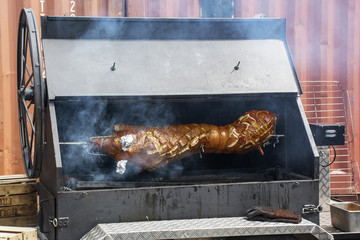 Big pork is roasting on a spit in the oven