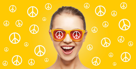 happy teenage hippy girl in shades with peace sign