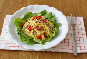 healthy lunch consists od corn spaghetti, salad, seeds and tomatoes