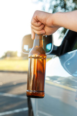 Car driver holding a bottle of beer