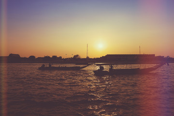 Fototapeta premium River boats crossing the Chao Phraya river in Bangkok, Thailand. with light leak filter.