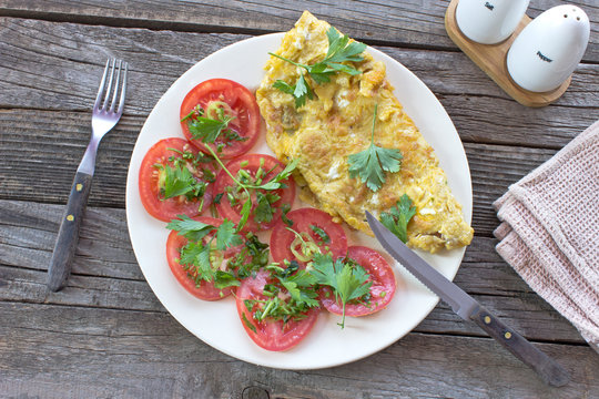 Omelette with vegetables on wooden background