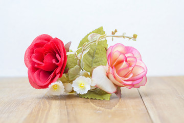 red and pink artificial rose on wooden board
