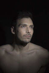 Portrait of beautiful young man looking to light.